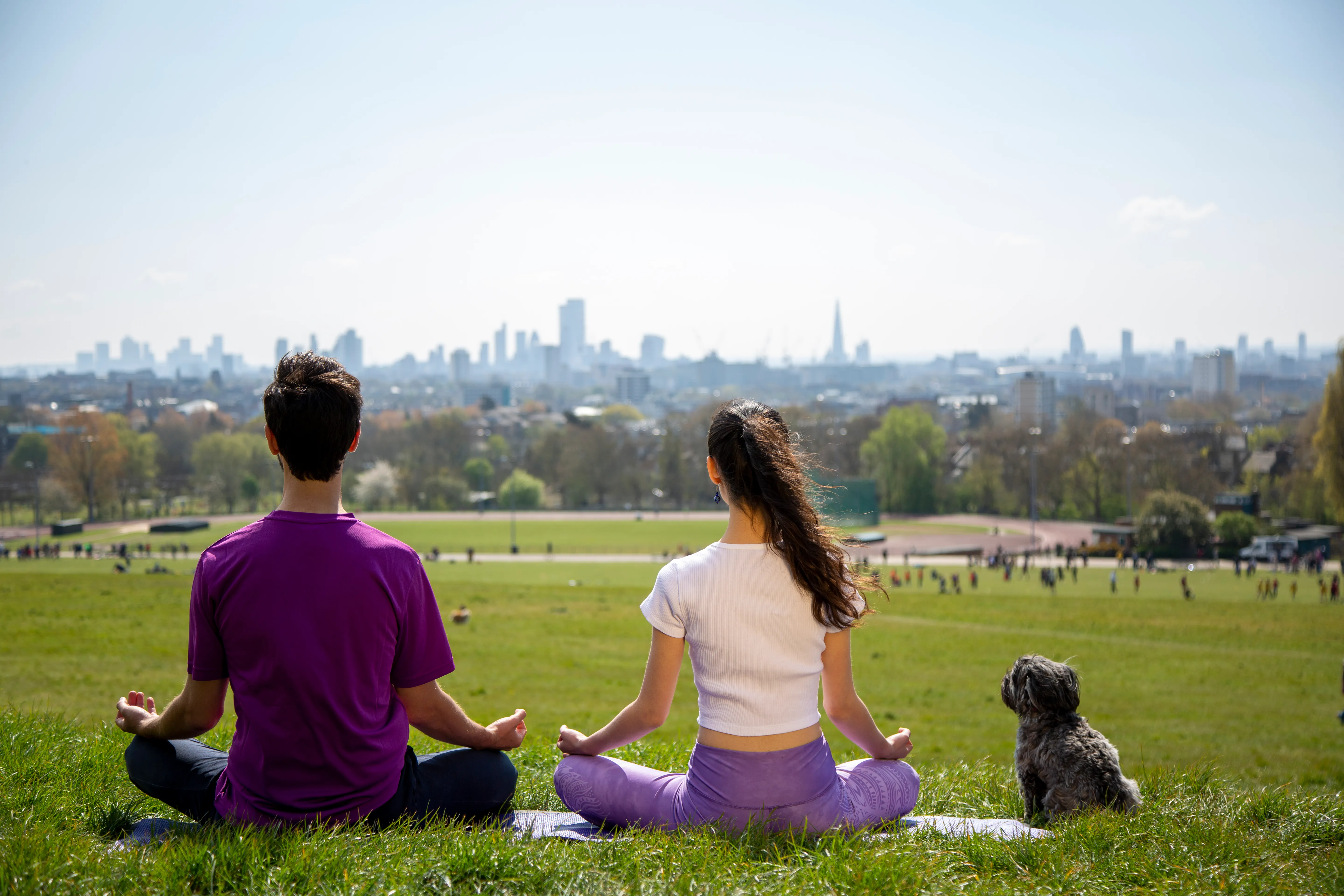 Couple sitting in meditation together overlooking the city